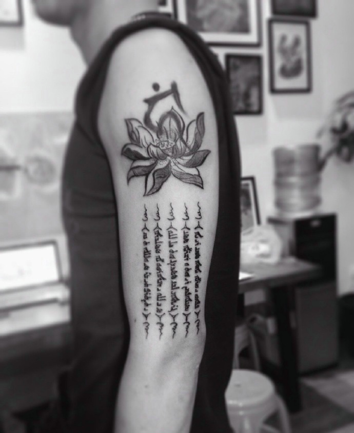 点击大图看下一张：莲花与梵文一起的大臂纹身刺青
