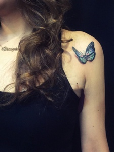 落在女生肩膀上的3d蝴蝶纹身刺青