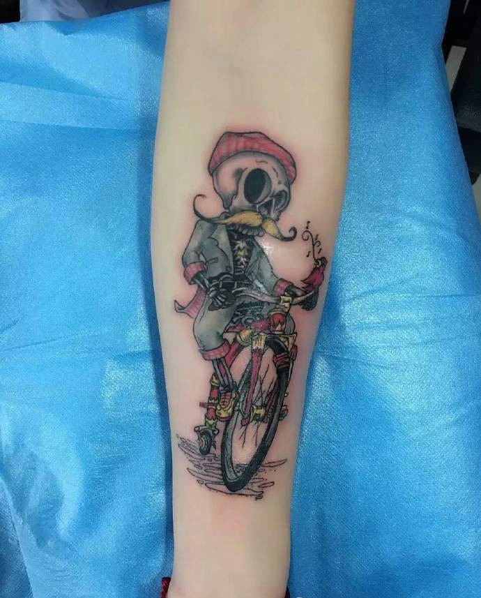 点击大图看下一张：骷髅老人骑自行车的手臂纹身图片
