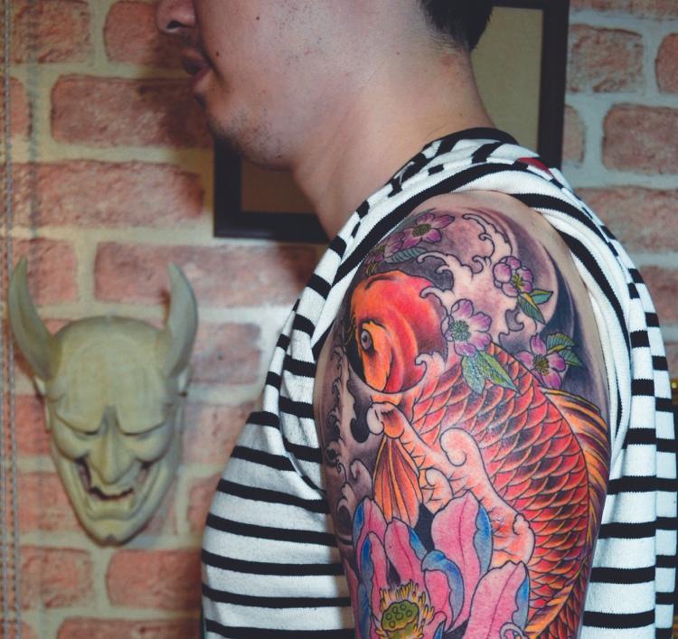 点击大图看下一张：遮盖整个大臂的彩色红鲤鱼纹身刺青