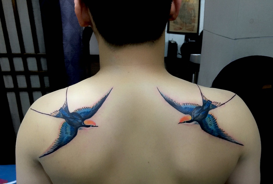 点击大图看下一张：后背穿花衣的两只小燕子纹身刺青