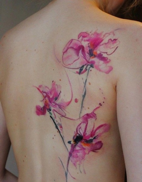 点击大图看下一张：色彩鲜艳的背部花朵纹身
