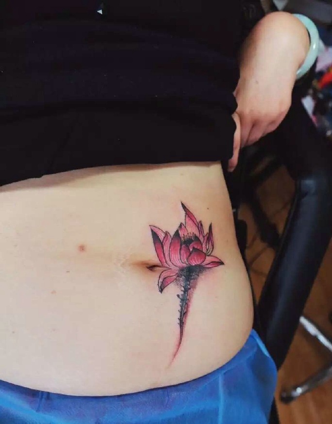 点击大图看下一张：女生肚脐边的一朵花朵纹身图片