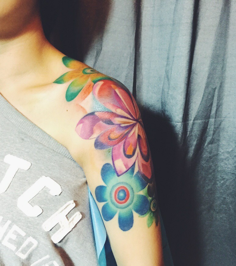 点击大图看下一张：肩部与手臂连在一起的花朵纹身刺青