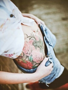 时尚女生的腹部美丽花朵纹身刺青