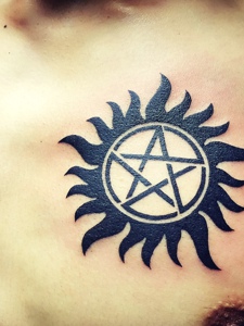 处在胸口的五角星小太阳纹身图案