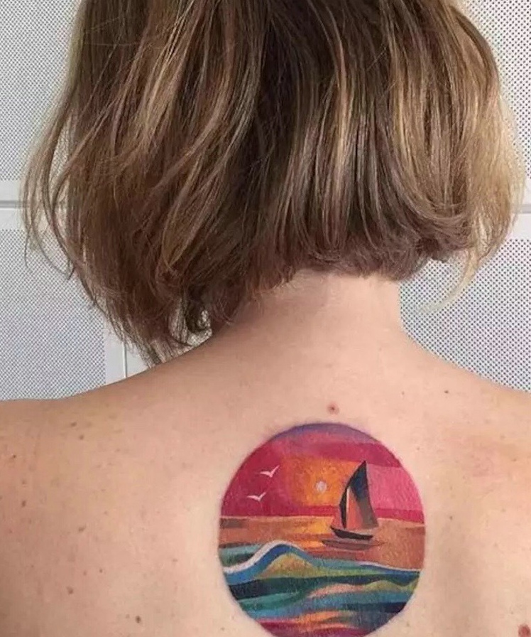 点击大图看下一张：女生后背夕阳下的海洋世界纹身图案
