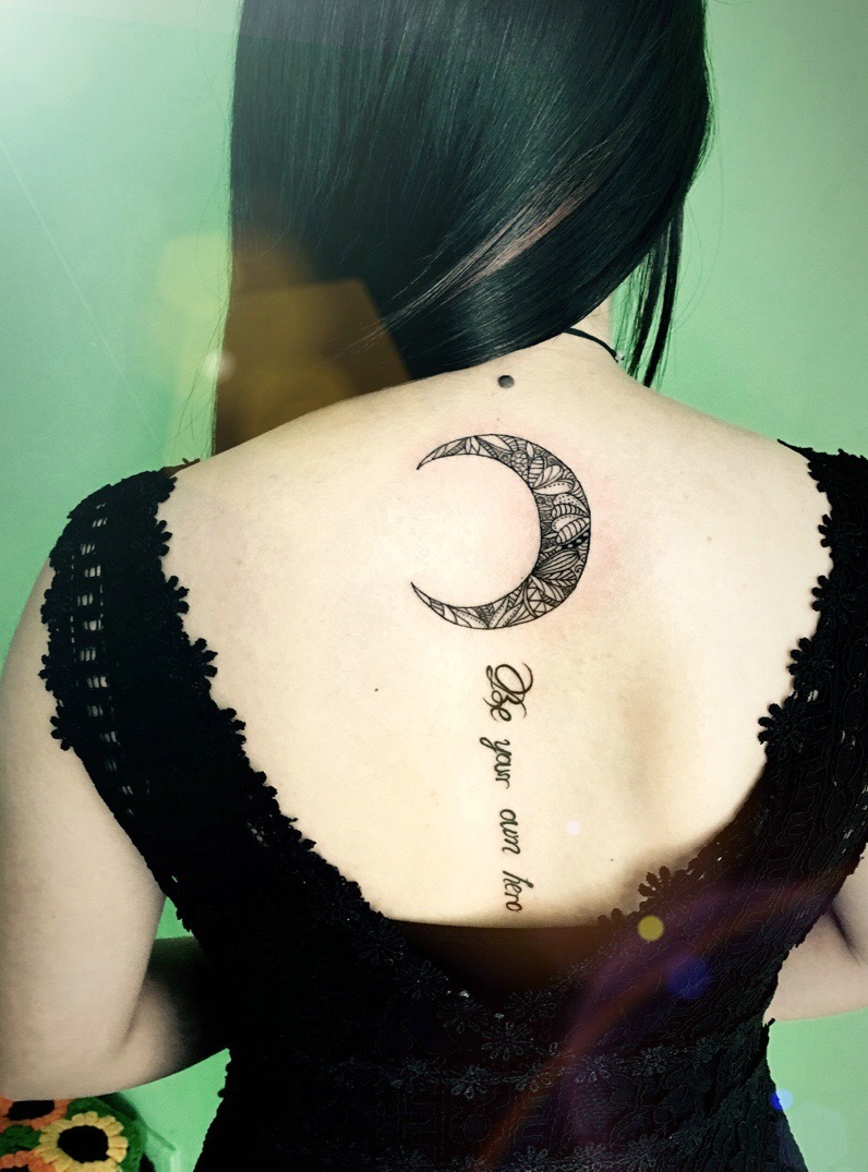 点击大图看下一张：长发女生脊椎部的月亮与英文的纹身图案