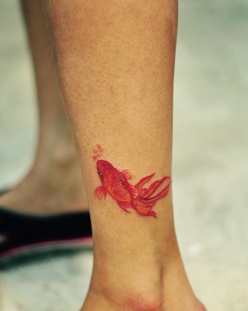 点击大图看下一张：停留在小腿部的小金鱼纹身图案