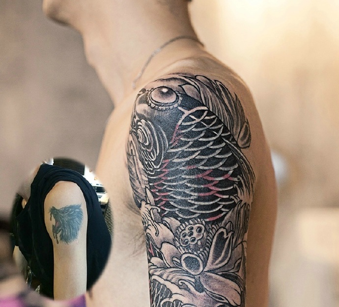 点击大图看下一张：大臂黑白鲤鱼纹身图案个性洒脱