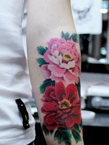 手臂外侧鲜艳的花朵纹身图案