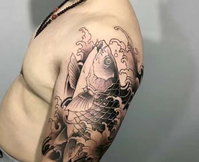 点击大图看下一张：魅力十足的大臂黑白鲤鱼纹身图案