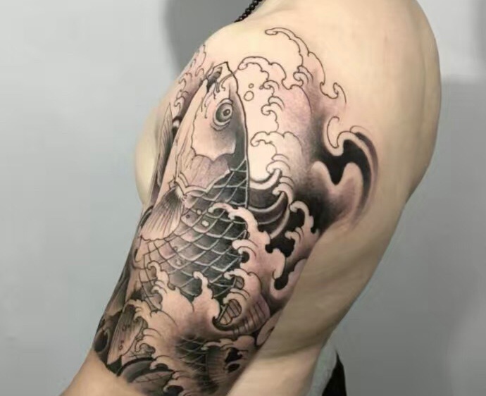 点击大图看下一张：魅力十足的大臂黑白鲤鱼纹身图案