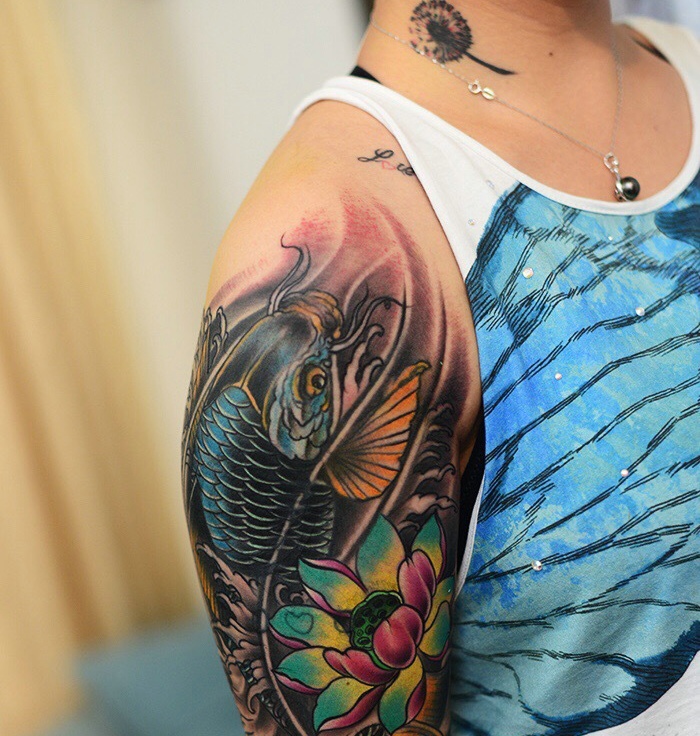 点击大图看下一张：莲花与鲤鱼结合的传统大臂纹身图案
