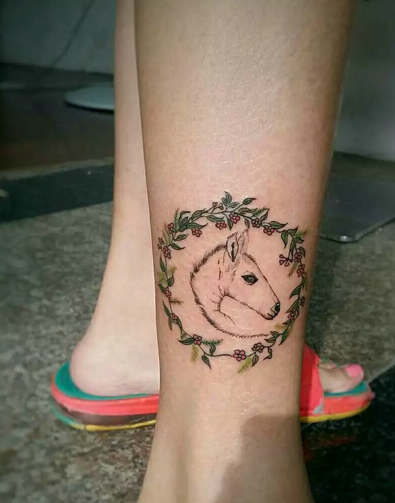 点击大图看下一张：被花环包围的小马头像腿部纹身图案