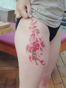 晳白的大腿部有着迷人的花朵纹身刺青