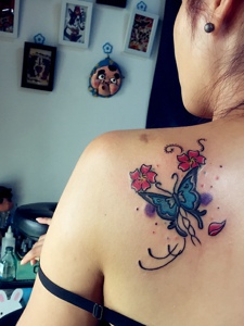 落在女生后背的彩色蝴蝶纹身图案
