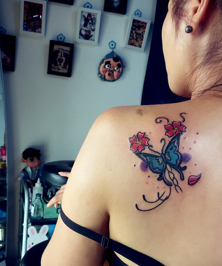 点击大图看下一张：落在女生后背的彩色蝴蝶纹身图案