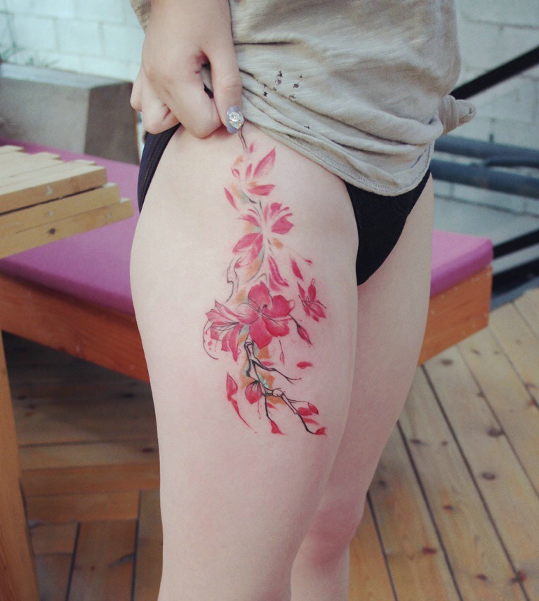 点击大图看下一张：晳白的大腿部有着迷人的花朵纹身刺青