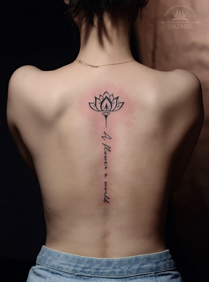 点击大图看下一张：莲花与英文的脊椎部纹身刺青