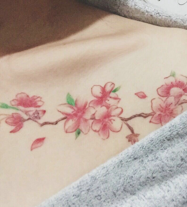 点击大图看下一张：锁骨女生胸前的优美梅花纹身刺青