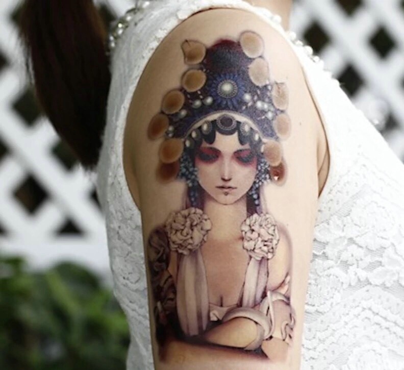 点击大图看下一张：手臂一枚心思重重的传统花旦纹身刺青