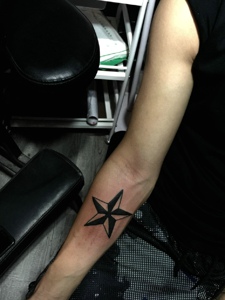 男士手腕上的简单五角星纹身刺青