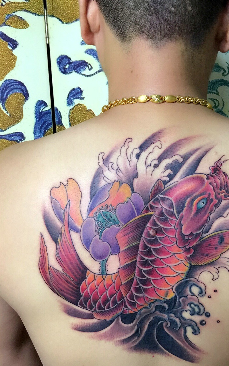 点击大图看下一张：莲花与鲤鱼结合的后背纹身图案