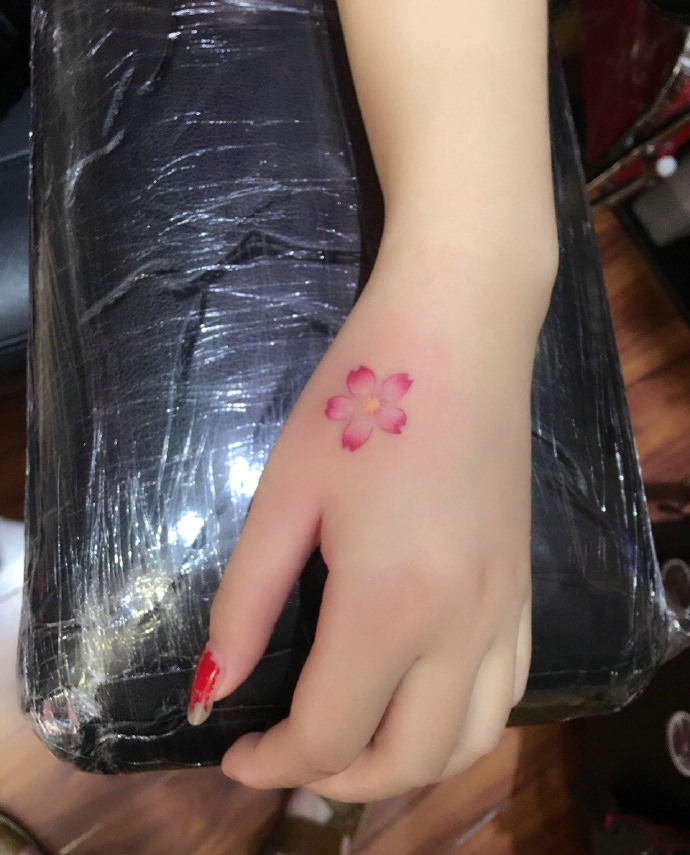 点击大图看下一张：让人心动不已的手背小樱花纹身刺青