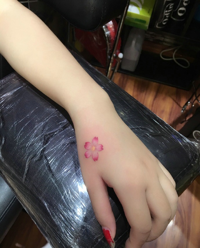 点击大图看下一张：让人心动不已的手背小樱花纹身刺青