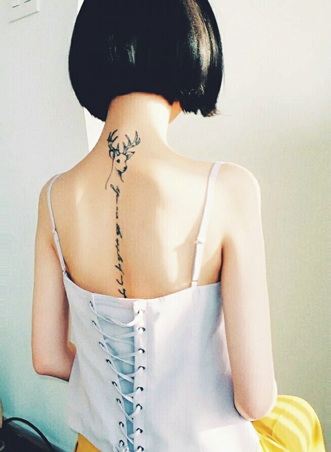点击大图看下一张：短发女孩脊椎部个性的英文纹身刺青