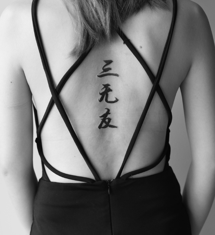 点击大图看下一张：非主流女孩脊椎部的汉字单词纹身刺青