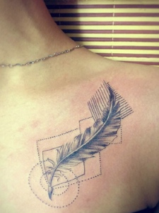 女生胸前几何与羽毛结合的纹身图片