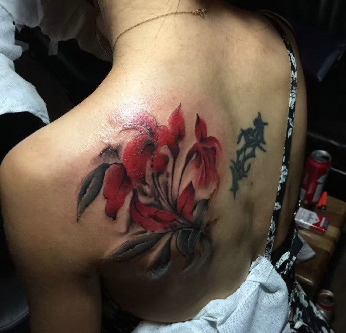 点击大图看下一张：女生后背美丽的花儿纹身图案
