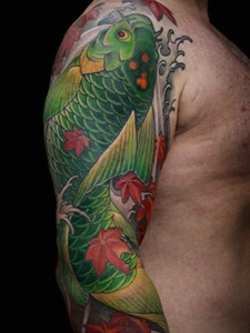 大臂鲜艳夺眼的绿色鲤鱼纹身图案