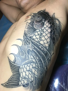 男士腰部上的黑白鲤鱼纹身图案