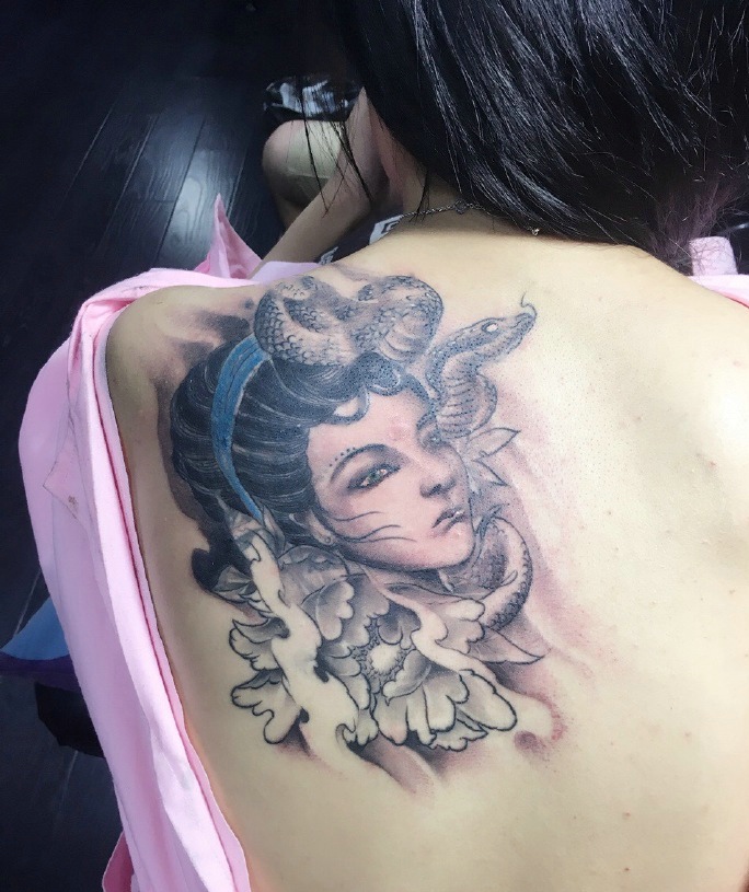 点击大图看下一张：女生背部一枚忧伤的美女肖像纹身刺青
