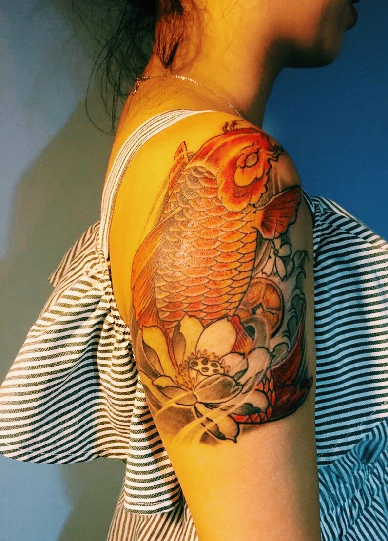 点击大图看下一张：莲花与金鲤鱼的花臂纹身图案