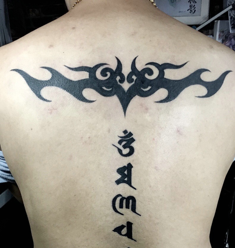 点击大图看下一张：梵文与图腾一起的脊椎部纹身刺青