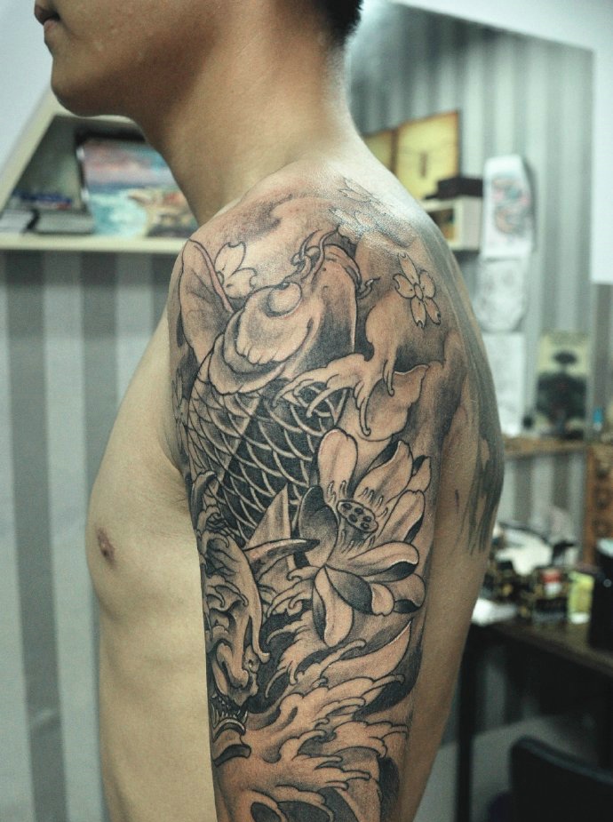 点击大图看下一张：莲花与鲤鱼的大臂黑灰纹身图案