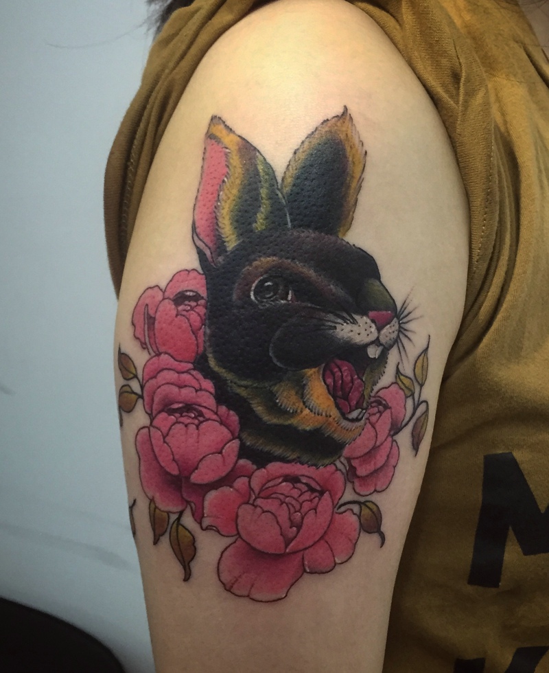 点击大图看下一张：爱花的小兔子大臂纹身图案