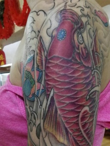 莲花与红鲤鱼结合的大臂纹身图案