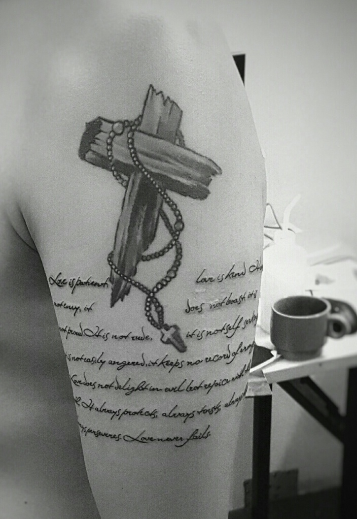 点击大图看下一张：十字架与英文结合的大臂纹身刺青