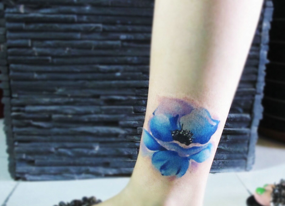 点击大图看下一张：裸脚外侧盛开着一朵蓝色花朵纹身