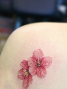 落在女生肩膀下的花瓣纹身刺青