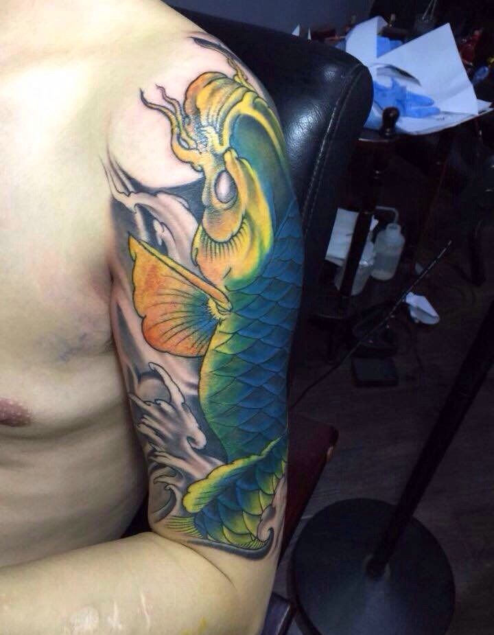 点击大图看下一张：大臂抢眼的彩色鲤鱼纹身图案