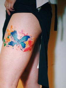 大腿处的水彩蝴蝶纹身图案很抢眼