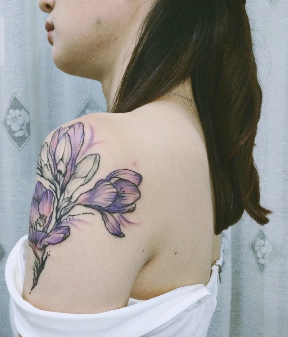 点击大图看下一张：女生香肩下的美丽兰花纹身图案