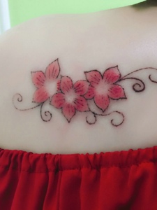 女生香肩下的一小串花朵纹身图案