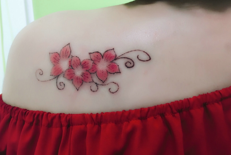 点击大图看下一张：女生香肩下的一小串花朵纹身图案